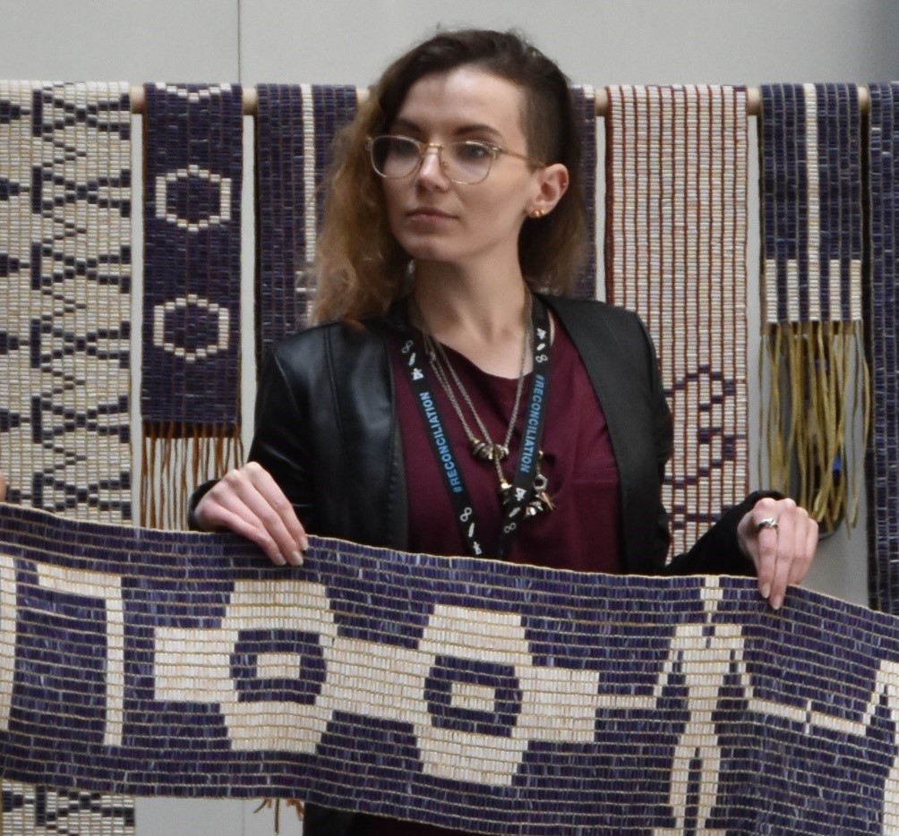 Alex at an Indigenous committee event in 2019 holding up a wampum belt
